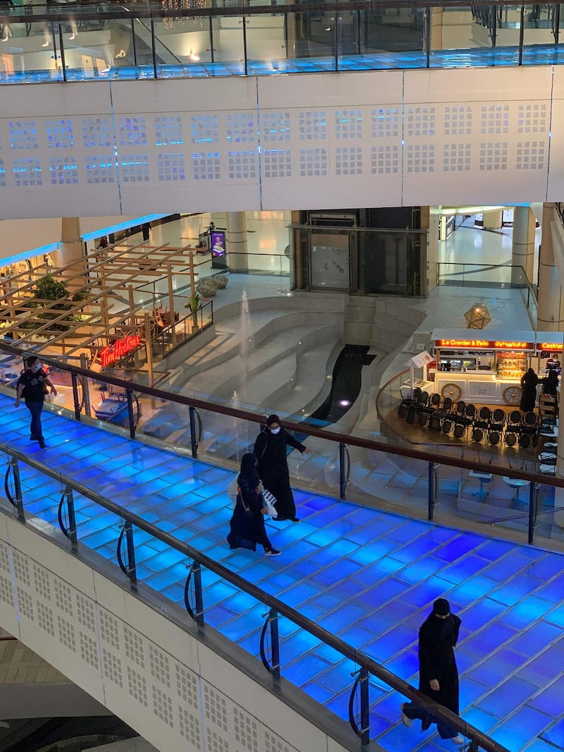 Shoppers cross a walkway above an empty food court at a mall in Saudi Arabia's capital Riyadh.  AFP