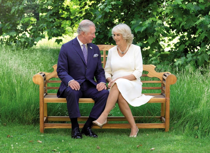 This photo released by Clarence House, shows the photo taken by Hugo Burnand of Britain's Prince Charles and Camilla, Duchess of Cornwall in the grounds of Clarence House, London, which is to be used as their 2018 Christmas card.  AP