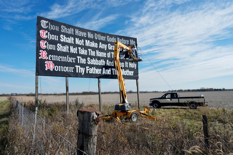 Workers repainting a 10 Commandments billboard on Interstate 71 in Ohio last year. AP
