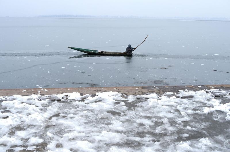 Kashmiri boatman break the ice to make his way on Dal Lake in Srinagar. AFP