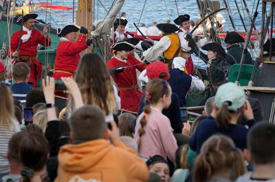 People watch a reconstruction of a battle between Russian and Sweden sailors during festivities marking the 350th birthday of Russian Tsar Peter the Great in St. Petersburg. AP