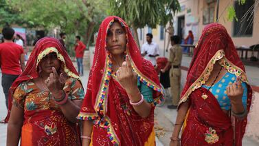 Women poses with their inked fingers at a polling station after casting their votes in the first phase of the general elections in Kotputli village in Rajasthan. EPA