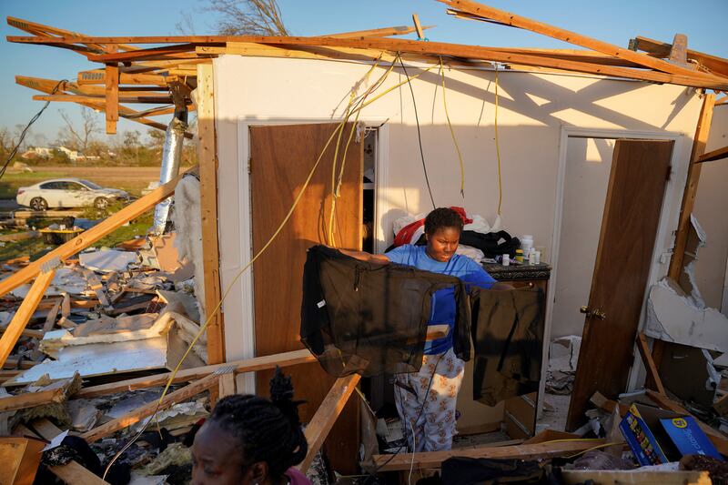 A teenager affected by the Mississippi tornado sorts his belongings. Reuters