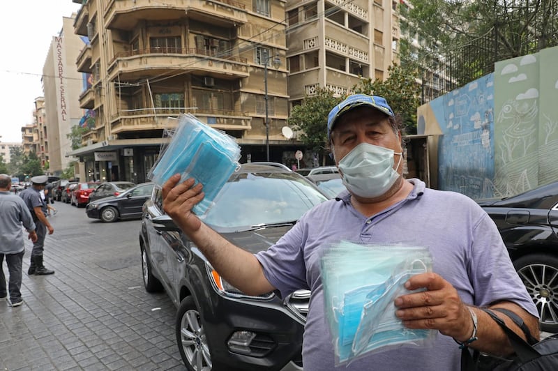 A man sells protective face masks in Beirut on July 29, 2020 ahead of lockdown measures after a spike in new cases threatened to overwhelm the crisis-hit country's healthcare system. - Lebanon, a country of some six million people, has recorded a total of 3,879 cases of COVID-19, including 51 deaths. (Photo by ANWAR AMRO / AFP)