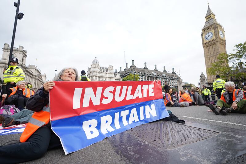 Climate activists from Insulate Britain block the road during a demonstration outside the Houses of Parliament. PA