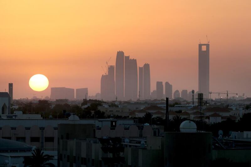 The sun sets behind the downtown Abu Dhabi skyline with a view of Etihad Towers. The lowest residential mortgage in the UAE currently starts at 3.5 per cent. Christopher Pike / The National





