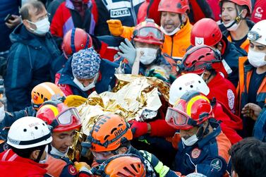 Three-year-old Elif Perincek holds on to the thumb her rescuer as she is carried out of a collapsed building in Izmir, Turkey, that collapsed in an earthquake three days earlier. Istanbul Fire Department / AFP