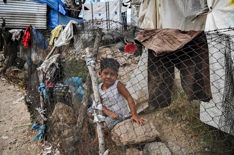 TOPSHOT - A child is pictured in a improvised tents camp near the refugee camp of Moria in the island of Lesbos on June 21, 2020. Greece's announcement that it was extending the coronavirus lockdown at its migrant camps until July 5, cancelling plans to lift the measures on June 22, coincided with World Refugee Day on June 27, 2020. / AFP / ARIS MESSINIS
