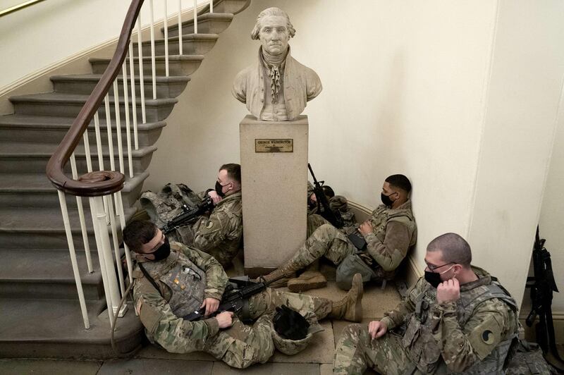 Members of the National Guard rest in the U.S. Capitol  in Washington, DC. Security has been increased throughout Washington following the breach of the U.S. Capitol last Wednesday, and leading up to the Presidential inauguration.   AFP