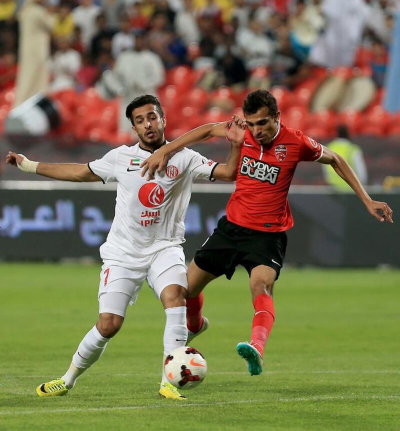 Ali Mabkhout, left, of Al Jazira fights for the ball with Walid Abbas of Al Ahli during their Arabian Gulf League match at Mohammed bin Zayed Stadium in Abu Dhabi on April 6, 2014. Ravindranath K / The National