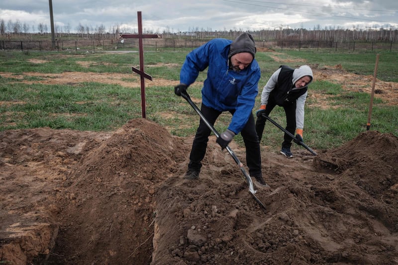 Residents bury two bodies in Bucha, north-west of Kyiv, where hundreds of people were found massacred. AFP