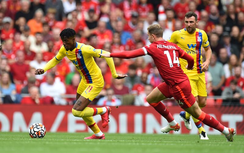 Wilfried Zaha runs with the ball under pressure from Liverpool's Jordan Henderson. Reuters