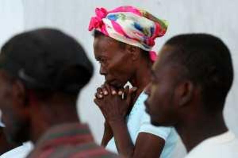 Haitian people pray during the sunday mass organized by the priest outside of the destroyed cathedral of Port au Prince on January 17, 2010, five days after an earthquake majoring 7.0 only open-ended Richter scale hit the Haitian capital.  AFP PHOTO / THOMAS COEX *** Local Caption ***  643996-01-08.jpg