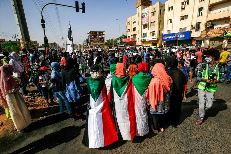 Sudanese protesters, some clad in masks as a precaution due to the coronavirus pandemic, gather to mark the first anniversary of a raid on an anti-government sit-in, in the Riyadh district in the east of the capital Khartoum.  AFP