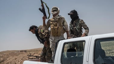 Members of an Iran-linked militia patrol near the Iraq-Syria border. Getty Images