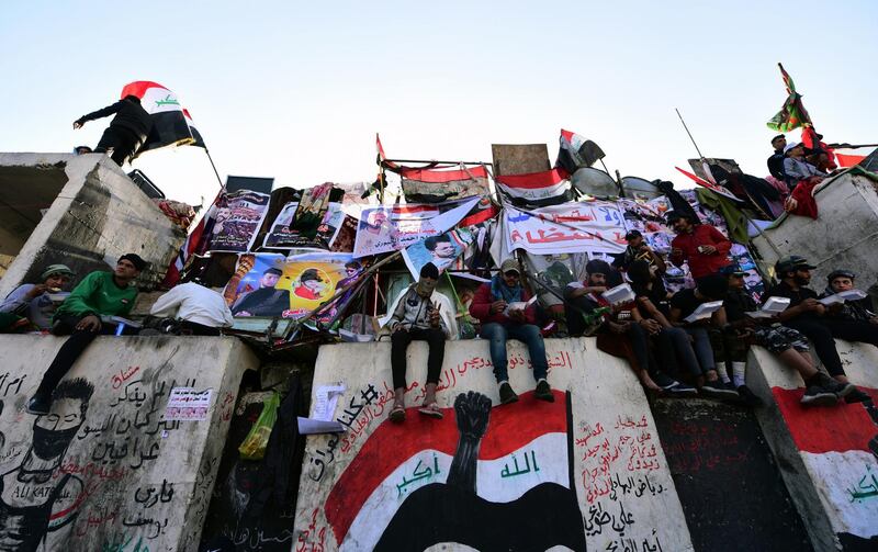 Protesters stand on concrete blocks which are used by security forces to block the Al Jumhuriya bridge. EPA