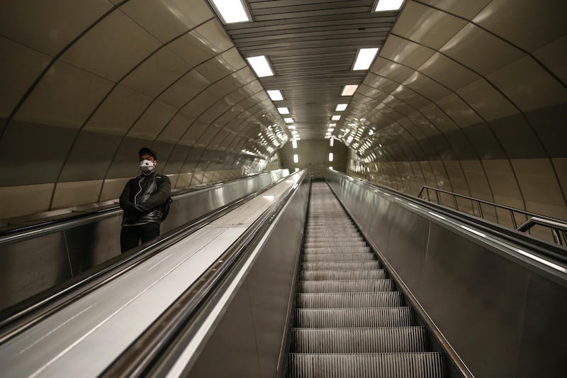 A commuter in a mask uses the escalators during the coronavirus outbreak in a nearly deserted underground station in central Istanbul, Friday, April 3, 2020. The new coronavirus causes mild or moderate symptoms for most people, but for some, especially older adults and people with existing health problems, it can cause more severe illness or death. (AP Photo/Emrah Gurel)