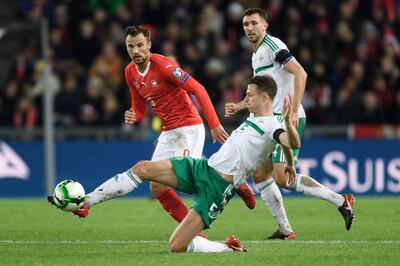 Northern Ireland's defender Jonny Evans (R) controls the ball next to Swiss foward Haris Seferovic during the FIFA 2018 World Cup play-off second leg qualifying football match between Switzerland and Northern Ireland at St Jakob-Park Stadium in Basel on November 12, 2017. / AFP PHOTO / Fabrice COFFRINI