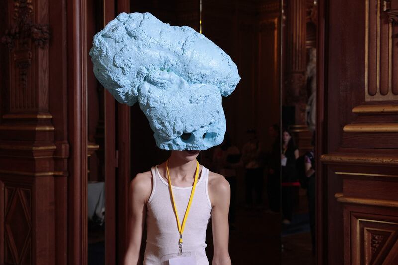 A model in a head-turning outfit waits backstage before a Paris fashion show. AFP