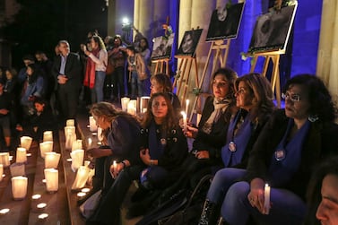 Lebanese activists carry candles in front of pictures depicting British embassy worker Rebecca Dykes and three Lebanese women during a sit-in in front of the national museum in Beirut on December 23, 2017. Nabil Mounzer / EPA