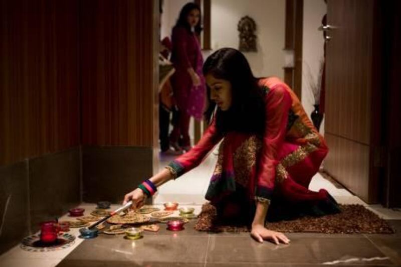 October 25, 2011, Sharjah, UAE:

To celebrate Diwali the Rajesh Jain family, and friends, have set out Diyas and Rangoli in front of their apartment.

Seen here is Priyal Jain, lighting the Diyas. 

Lee Hoagland/The National