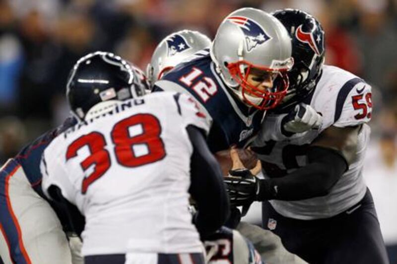 Houston Texans' Danieal Manning and Whitney Mercilus block New England's Tom Brady.