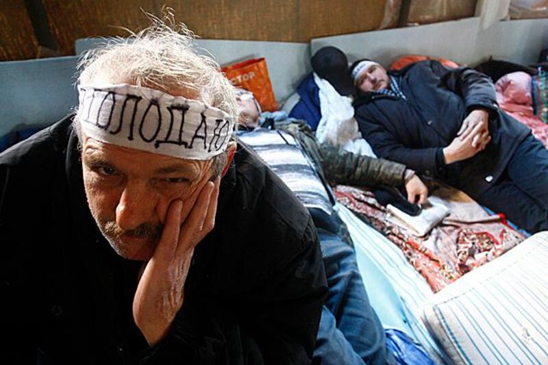 Liquidators or emergency workers, who fought the blaze at the Chernobyl nuclear reactor, take part in a hunger strike inside a tent near the regional pension fund office in Donetsk November 23, 2011. Protesters have taken part in the hunger strike for 10 days to demand the authorities to pay out their subsidies and benefits guaranteed by the law, according to local media. The bandage reads "I am starving". REUTERS/Valeriy Bilokryl (UKRAINE - Tags: CIVIL UNREST POLITICS ENERGY ENVIRONMENT BUSINESS)