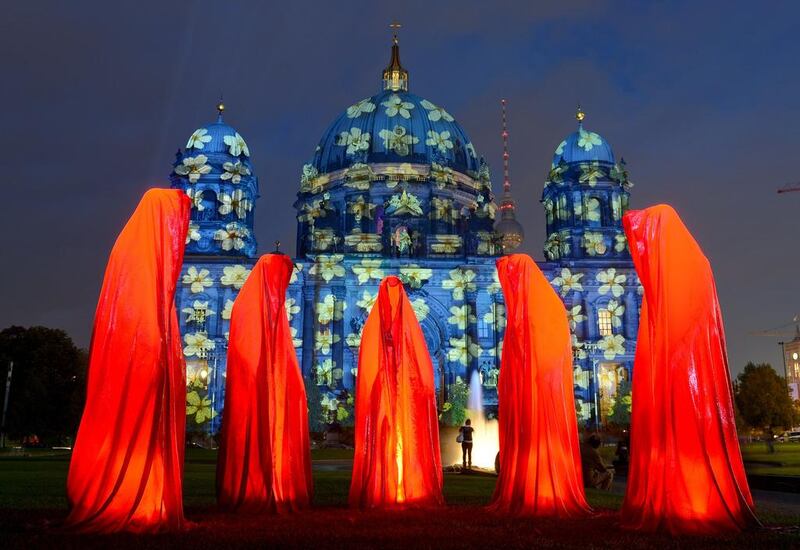 The installation 'Keeper of Time' is seen in front of an enlightened Berlin Cathedral n the first day of Festival of Lights. Britta Pedersen / DPA / AFP Photo