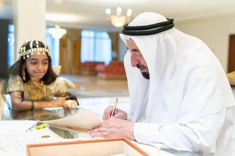 Rayan Al Khori watches as Sharjah Ruler, Sheikh Dr Sultan bin Muhammad Al Qasimi signs certificates in the palace. Courtesy: Sheikh Dr Sultan / Instagram  