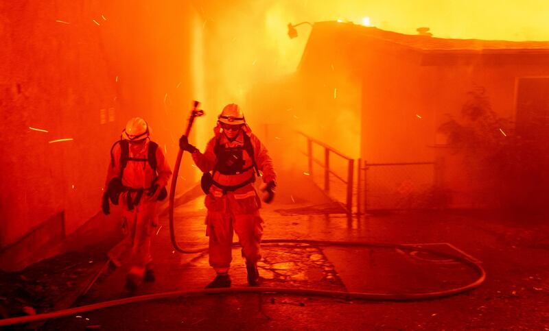 FILE - In this Thursday, Nov. 8, 2018 file photo, firefighters battle the Camp Fire as it tears through Paradise, Calif. Rain in the forecast starting Wednesday, Nov. 21, could aid crews fighting Northern California's deadly wildfire while raising the risk of debris flows and complicating efforts to recover remains. The National Weather Service has issued a flash flood watch Wednesday for the decimated town of Paradise and nearby communities. (AP Photo/Noah Berger, File)