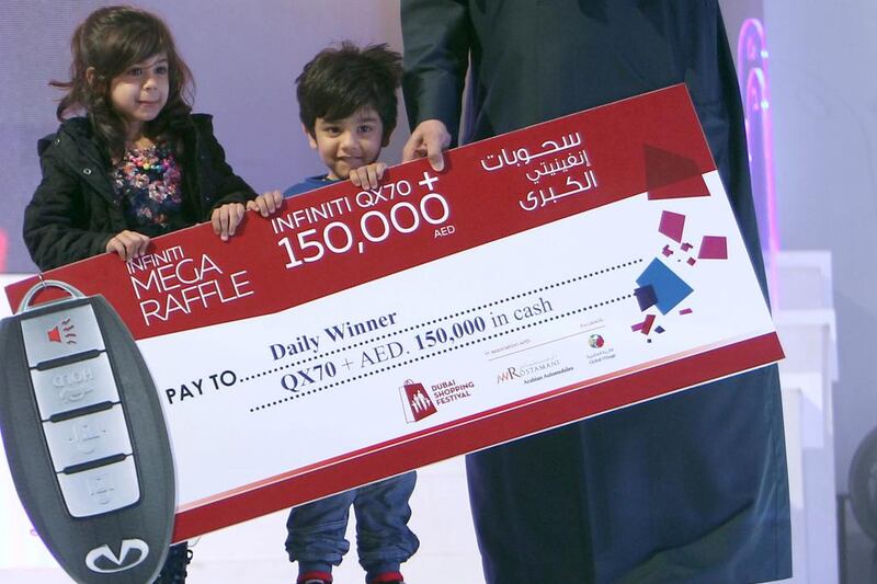 Three-year-old Talal Al Hammar accepts his reward for winning the Dubai Shopping Festival raffle. Courtesy Dubai Tourism