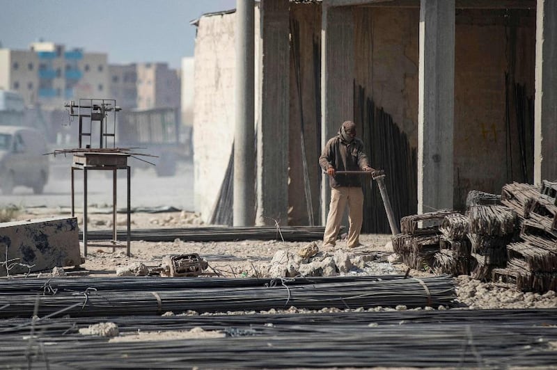 A man bends steel rods at a makeshift workshop in Raqqa.
