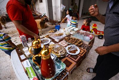 Libyans eat desserts after breaking their fast on the evening prior to the start of the Muslim religious festival of Eid al-Adha in the Libyan capital Tripoli on August 10, 2019. Known as the "big" festival, Eid Al-Adha is celebrated each year by Muslims sacrificing various animals according to religious traditions, including cows, camels, goats and sheep. / AFP / Mahmud TURKIA
