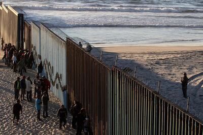 Central American migrants moving towards the United States in hopes of a better life, stand by the US-Mexico border fence in Playas de Tijuana, Mexico, on November 14, 2018.  US Defence Secretary Jim Mattis said Tuesday he will visit the US-Mexico border, where thousands of active-duty soldiers have been deployed to help border police prepare for the arrival of a "caravan" of migrants. / AFP / Guillermo Arias

