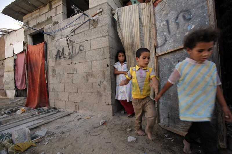 Heba Alwadiya, 11, stands at a cloth-covered door as her sister and brother leave their house. Adel Hana / AP



