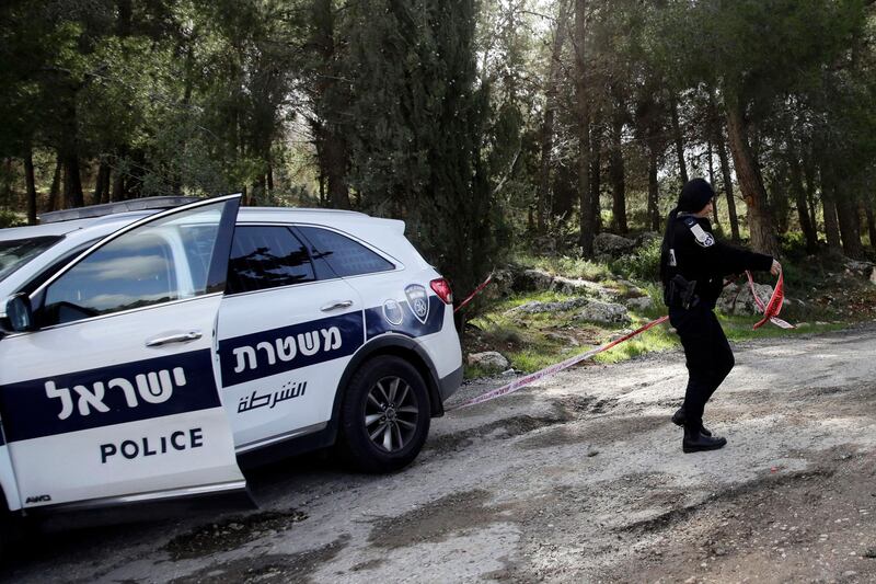 FILE - In this Friday, Feb. 8, 2019 file photo, an Israeli police officer blocks the area where the body of an Israeli woman was found in Jerusalem. Israel's internal security agency said in a statement Sunday Feb. 10, 2019, the murder of a 19-year-old Israeli woman by a Palestinian suspect near Jerusalem last week was politically motivated.(AP Photo/Mahmoud Illean)