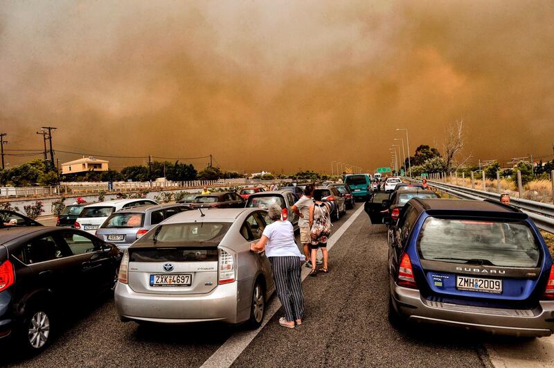 Cars are blocked at the closed National Road during a wildfire in Kineta, near Athens. AFP