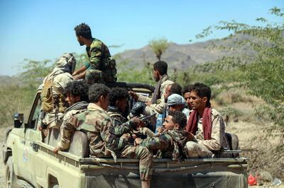 Forces loyal to Yemen's Saudi-backed government sit in the back of a pick-up truck as they deploy during clashes with Huthi rebel fighters west of the country's third-city of Taez, on March 16, 2021. / AFP / Ahmad AL-BASHA
