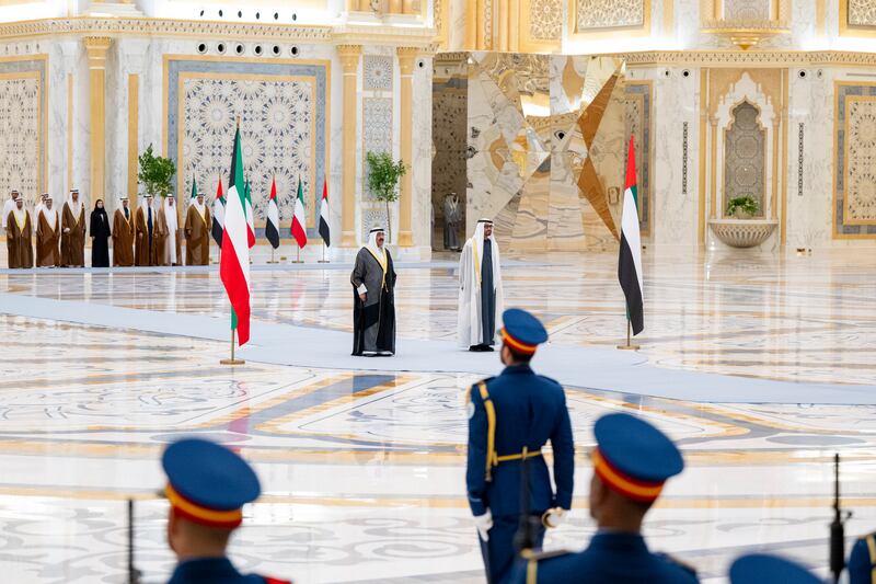 Sheikh Mohamed and Sheikh Meshal stand for their national anthems at Qasr Al Watan. Abdulla Al Bedwawi / UAE Presidential Court