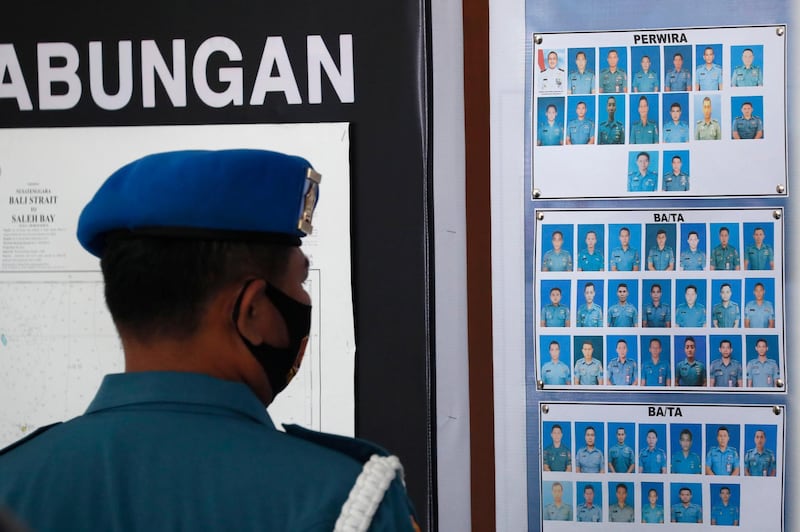 A military officer looks at the pictures of crew members of the missing Indonesian Navy submarine KRI Nanggala. EPA