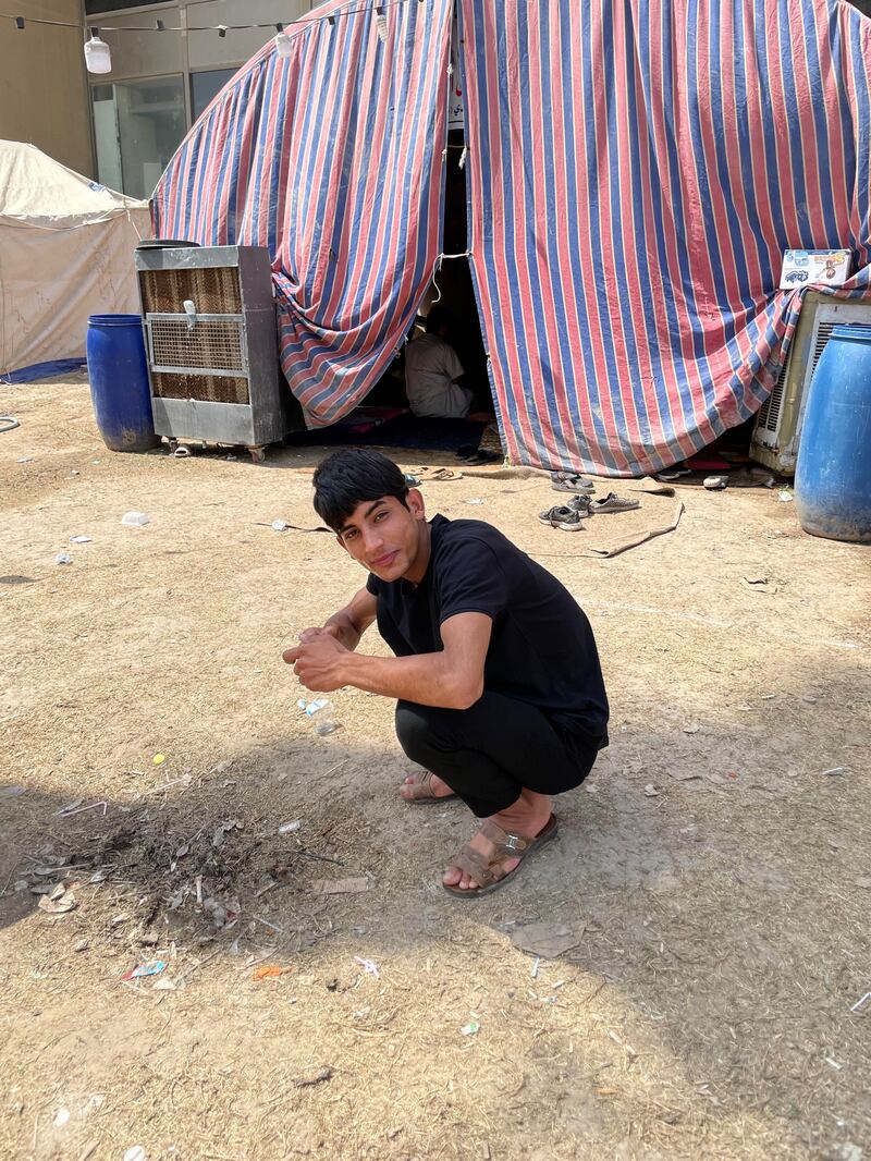 Murtadha Riyadh, 19, splashes cold water on his face to beat the heat outside the tent he and others sleep in. 