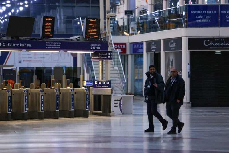 Workers work along the deserted concourse of London's Victoria railway station. Bloomberg