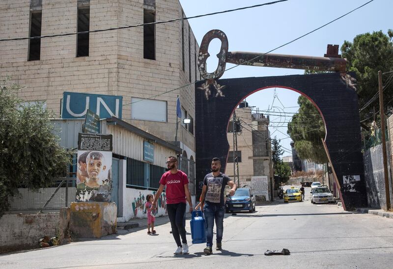 Palestinians carry cooking gain the entrance of the Aida refugee camp near the city of Bethlehem on June 23,2019.Photo by Heidi Levine for The National