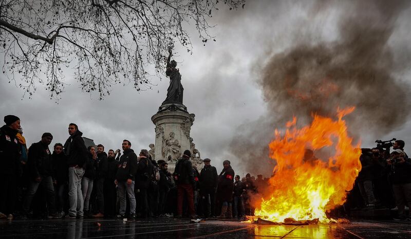 epa07214688 A trashcan burns on Place de la Republique as students demonstrate against the increase of the subscription fees for foreigners students, in Paris, France, 07 December 2018. This movement takes place while the government is facing a major contestation by the so called movement of the Gilets Jaunes (Yellow Vests).  EPA/IAN LANGSDON