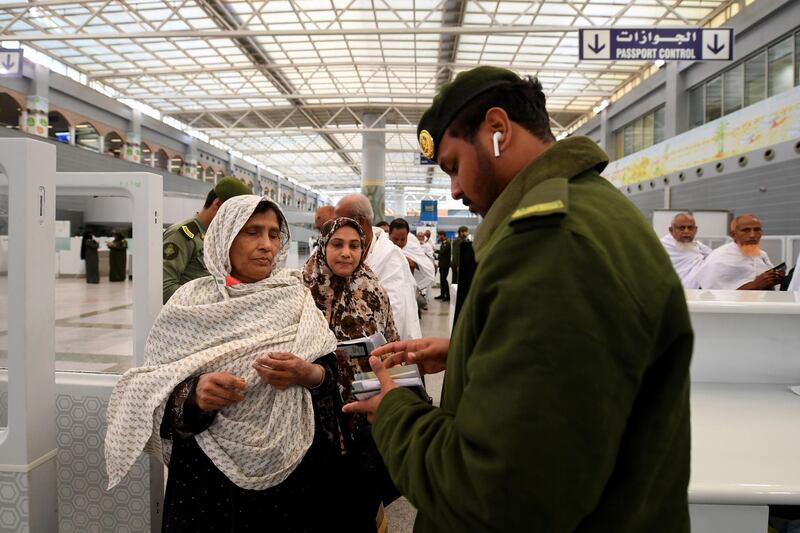 Pilgrims go through passport control. AFP