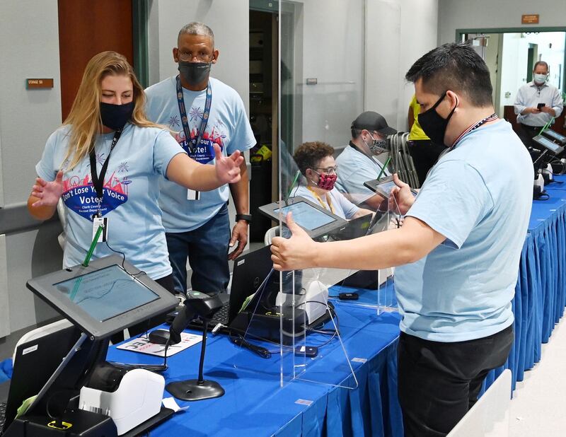 Workers set up plexiglass safety shields in front of kiosks at a voting site in Las Vegas, Nevada, where in-person early voting for the US elections begins on October 17.  AFP