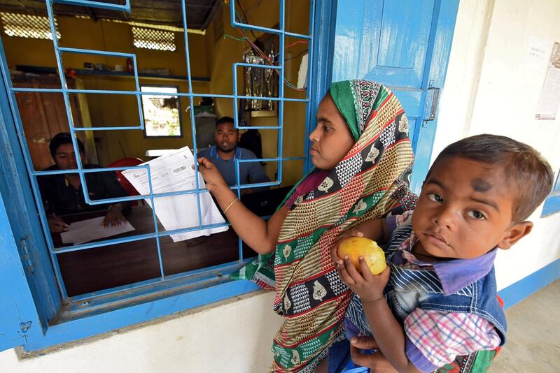 FILE PHOTO: A woman carrying her son arrives to check her name on the draft list of the National Register of Citizens (NRC) at an NRC center in Chandamari village in Goalpara district in the northeastern state of Assam, India, January 2, 2018. Picture taken January 2, 2018. REUTERS/Anuwar Hazarika/File Photo