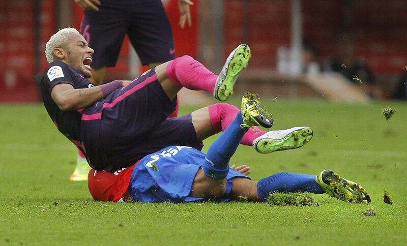 Neymar reacts after getting tackled by Sporting Gijon’s Ignacio Cases. Jose Luis Cereijido / EPA