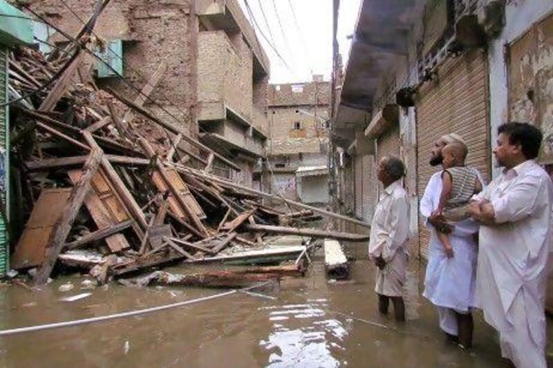 Pakistani residents look at a collapsed house caused by torrential rain in Sukkur yesterday.