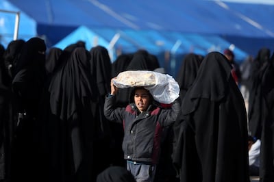 A boy carries bread on his head at al-Hol displacement camp in Hasaka governorate, Syria April 2, 2019. Picture taken April 2, 2019. REUTERS/Ali Hashisho
